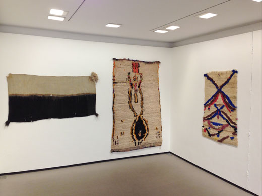 the Douglas Hyde Gallery, Dublin, Ireland: 'Textiles from the Atlas Mountains', a seemingly 'figurative' rug from Azilal (center), central High Atlas, a small saddle rug from the central Middle Atlas (right) + a highly rare women's veil from Ait Abdellah in the Anti-Atlas