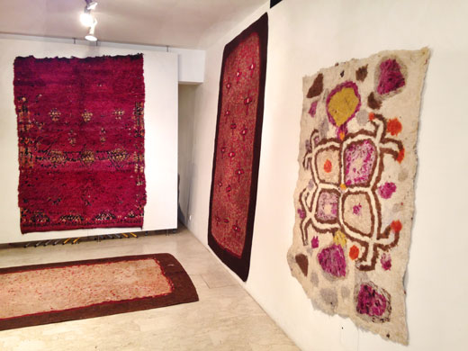 a deep purple Beni Mguild rug on the back wall, a double sided turkmen felt rug on the bottom + in the background on the right wall + another Afghan felt rug in the foreground